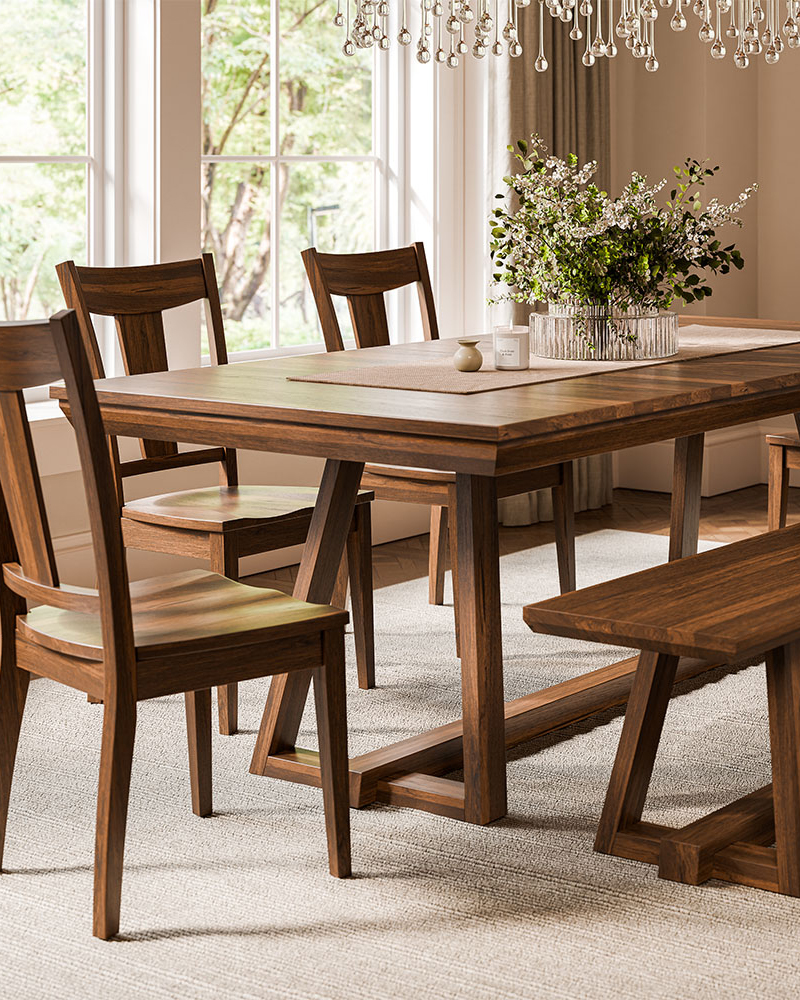 Solid wood dining room furniture with trestle table, chairs, and bench.