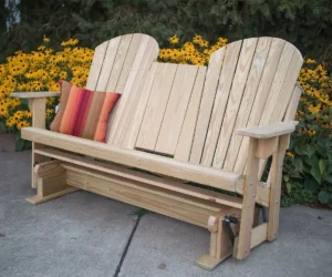 Wooden Adirondack glider bench with colorful cushions outdoors.