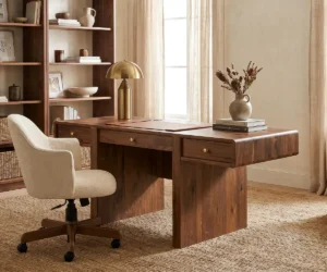Solid wood desk in a home office with natural light and upholstered chair