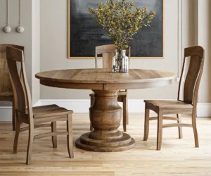Round solid wood pedestal dining table paired with handcrafted wooden chairs.